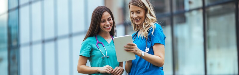 Two nurses reviewing patient information on a tablet