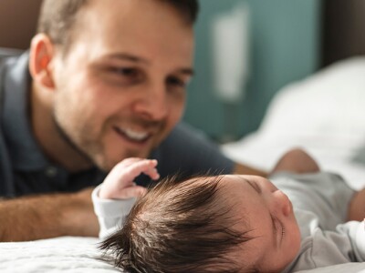 A couple with newborn baby on a bed