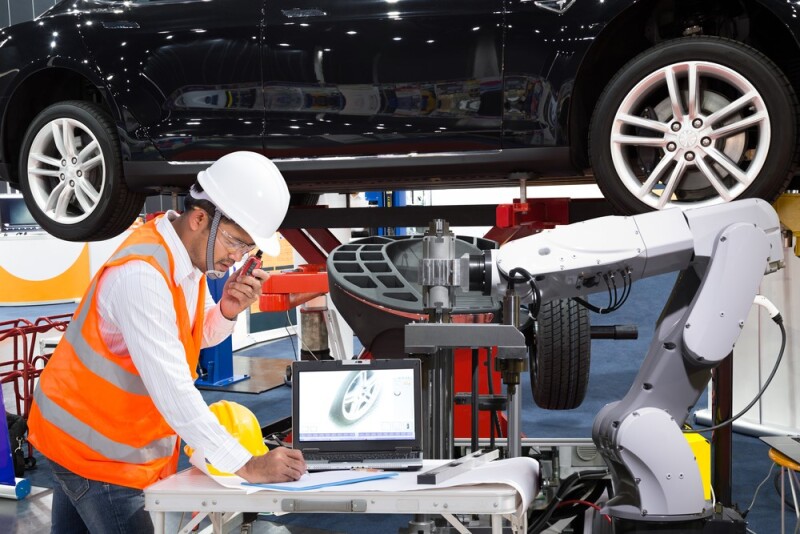 automotive engineer working next to a raised car