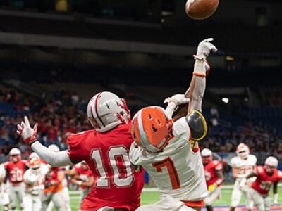 red-white-jersey-football-players-jumping-for-ball-in-stadium