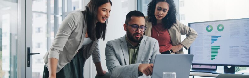 Two females standing next to their male colleague collaborating on ideas