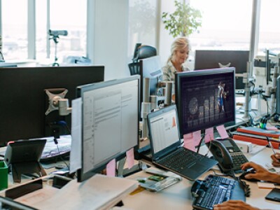 Office staff using computers to research top sports analytics jobs.